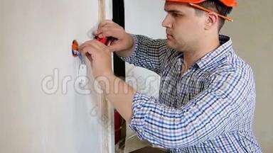 男建造工或施工工人用测量胶带测量墙壁的特写慢动作视频.. 男人